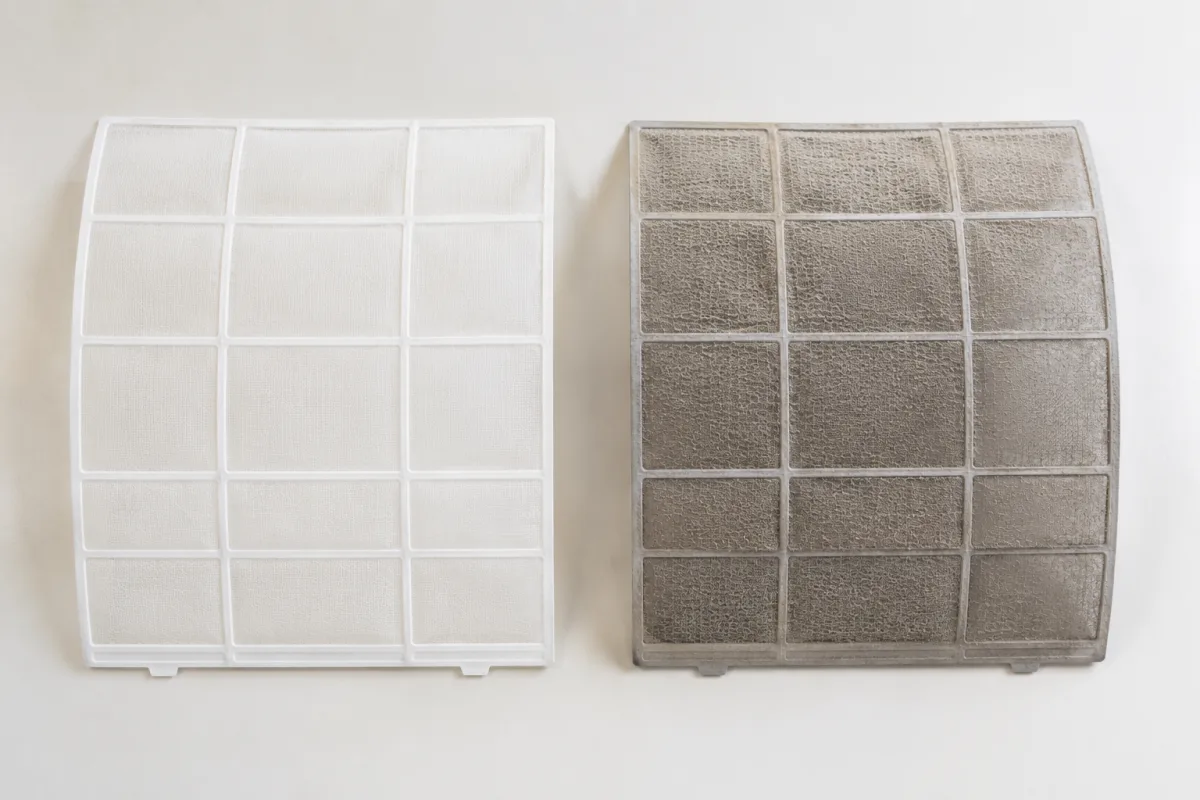 Side-by-side comparison of a clean white split system filter next to a dirty grey filter caked with dust and lint after months of use