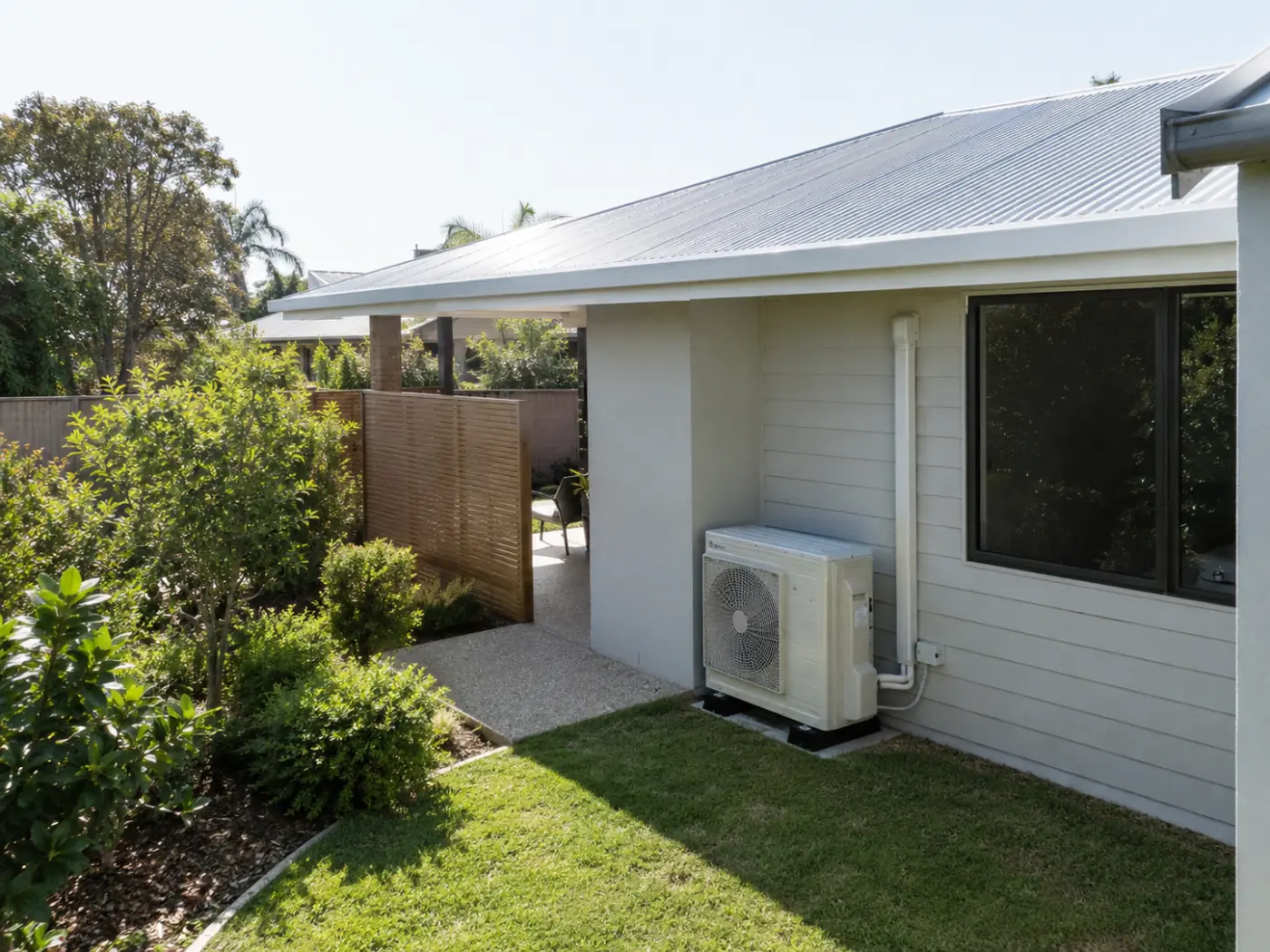 Modern Coffs Harbour home with a professionally installed outdoor air-conditioning condenser beside the house.